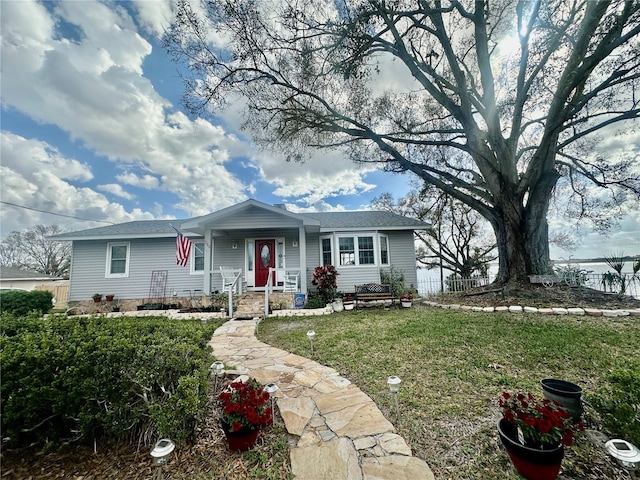 ranch-style home with covered porch and a front yard