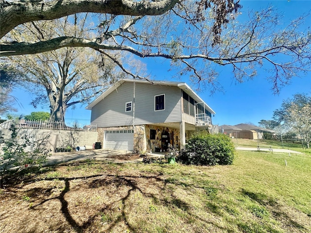 view of front of house featuring a front yard, a garage, and a sunroom