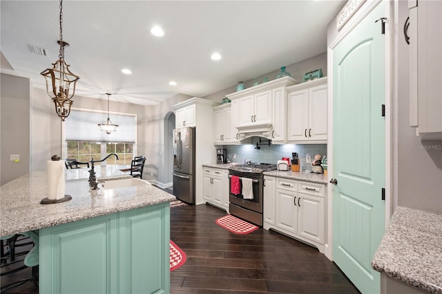 kitchen featuring white cabinetry, a center island with sink, stainless steel appliances, and pendant lighting