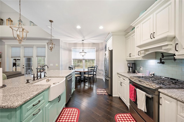 kitchen featuring a chandelier, sink, decorative light fixtures, stainless steel appliances, and an island with sink