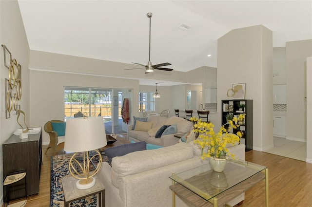 living room featuring ceiling fan, light hardwood / wood-style floors, and high vaulted ceiling