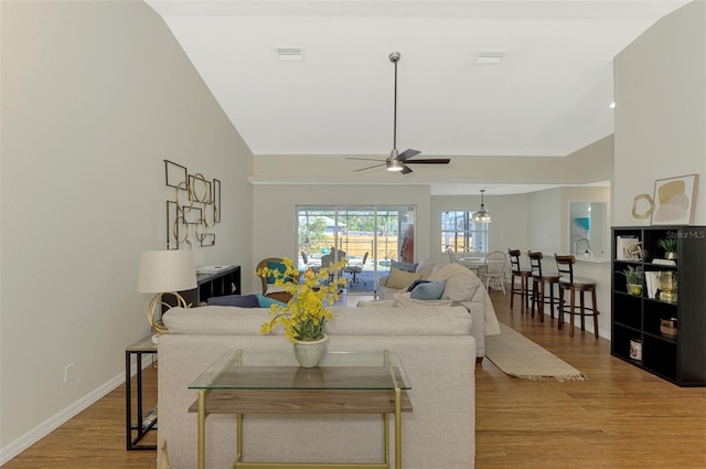 living room with light wood-type flooring, lofted ceiling, and ceiling fan