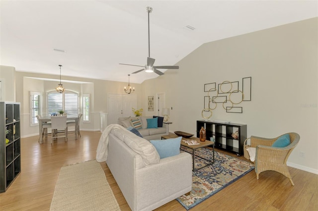 living room featuring ceiling fan, light wood-type flooring, and lofted ceiling