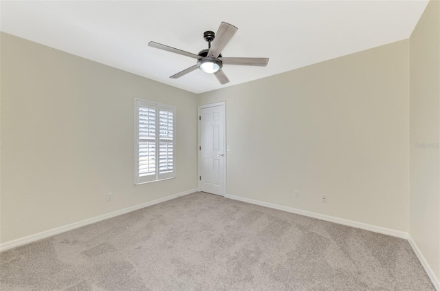 carpeted spare room with ceiling fan