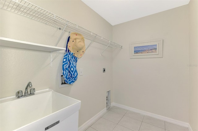 laundry area featuring sink, hookup for an electric dryer, and light tile patterned floors