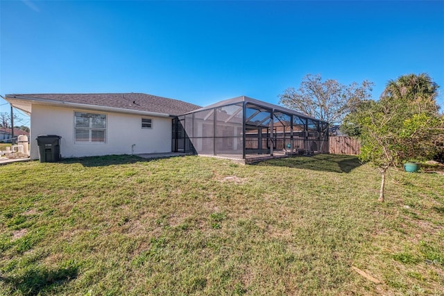 rear view of property featuring a yard and a lanai