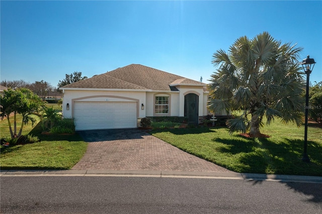 mediterranean / spanish house with a front lawn and a garage