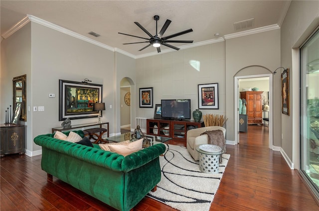 living room featuring ceiling fan, dark wood-type flooring, and crown molding