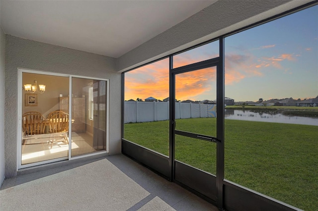 sunroom with a water view and a notable chandelier