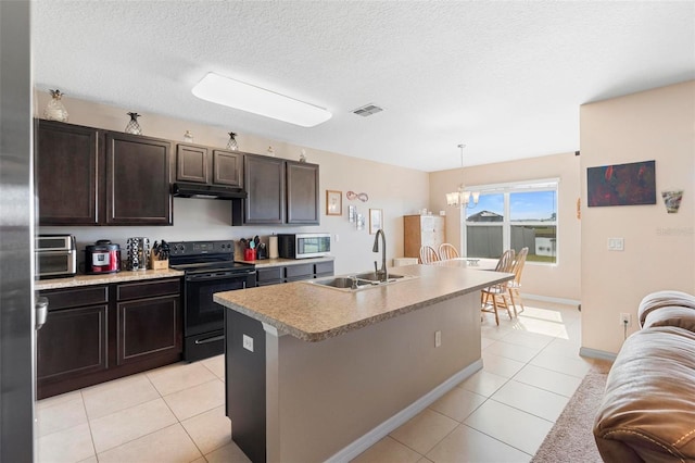 kitchen with light tile patterned floors, stainless steel microwave, black range with electric stovetop, a sink, and under cabinet range hood