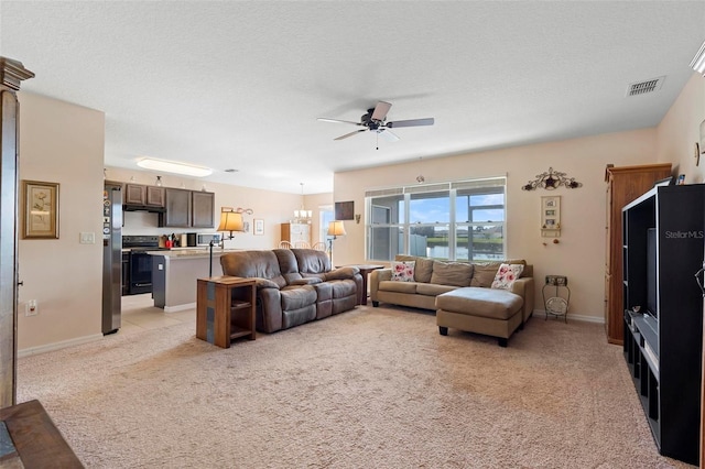 living area with a textured ceiling, ceiling fan with notable chandelier, baseboards, and light colored carpet