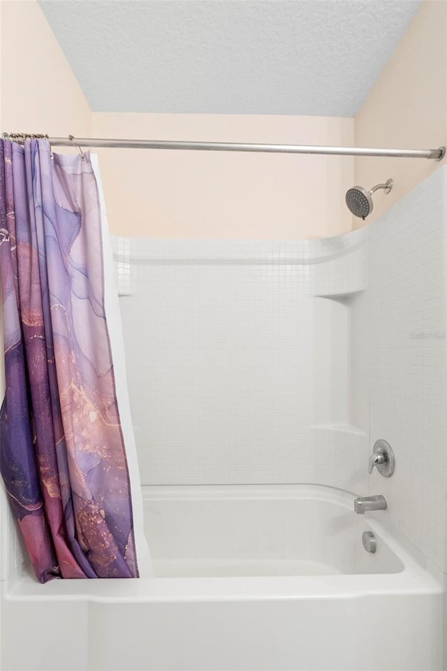 bathroom featuring shower / tub combo and a textured ceiling