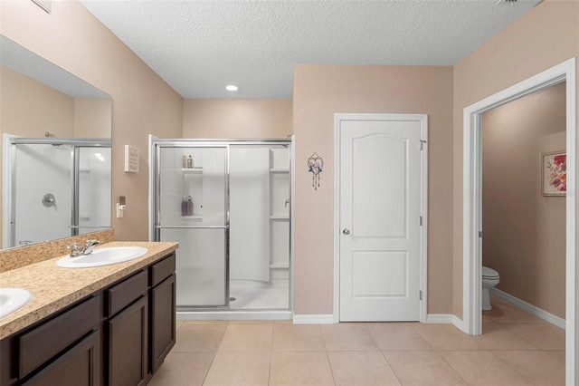 full bath featuring a textured ceiling, toilet, a sink, a shower stall, and tile patterned floors