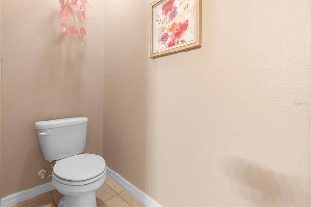 bathroom featuring tile patterned flooring, toilet, and baseboards