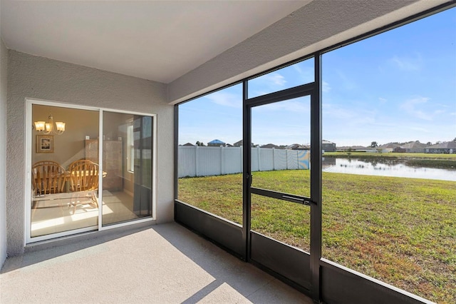 unfurnished sunroom with a water view and an inviting chandelier
