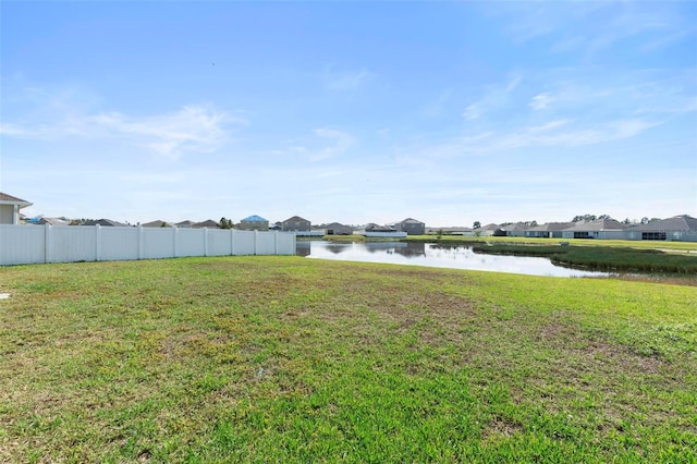 view of yard featuring a water view and fence