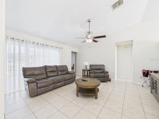 living room with light tile patterned floors, visible vents, and vaulted ceiling