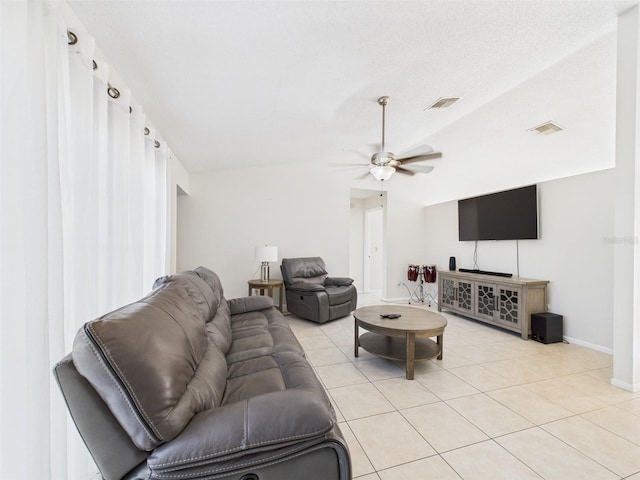 living room featuring light tile patterned floors, lofted ceiling, and visible vents