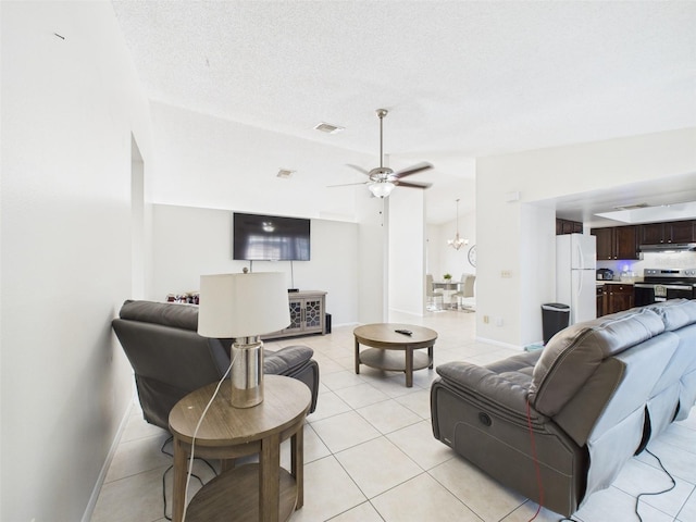 living area featuring visible vents, light tile patterned flooring, vaulted ceiling, a textured ceiling, and ceiling fan with notable chandelier