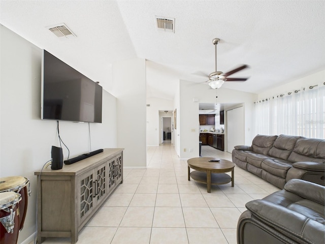 living area featuring a ceiling fan, visible vents, vaulted ceiling, and light tile patterned floors