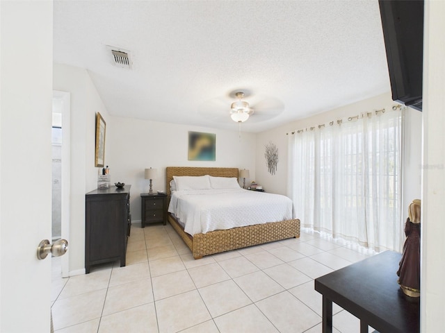 bedroom with ceiling fan, visible vents, a textured ceiling, and light tile patterned flooring