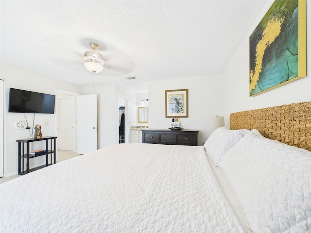 bedroom with ceiling fan, visible vents, and a textured ceiling