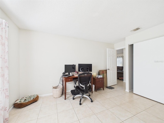 office area featuring visible vents, a textured ceiling, and light tile patterned floors