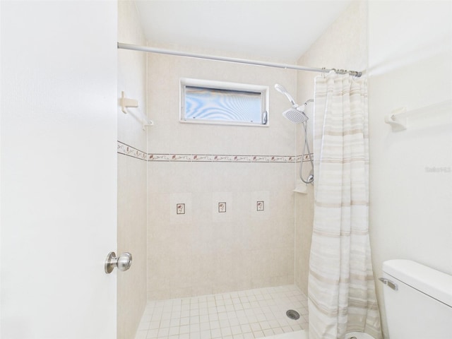 bathroom featuring a shower stall and toilet