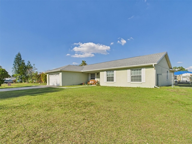 ranch-style home featuring a front lawn, fence, and an attached garage