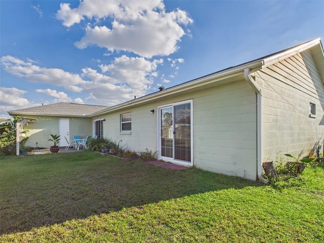 rear view of house with a patio area and a yard