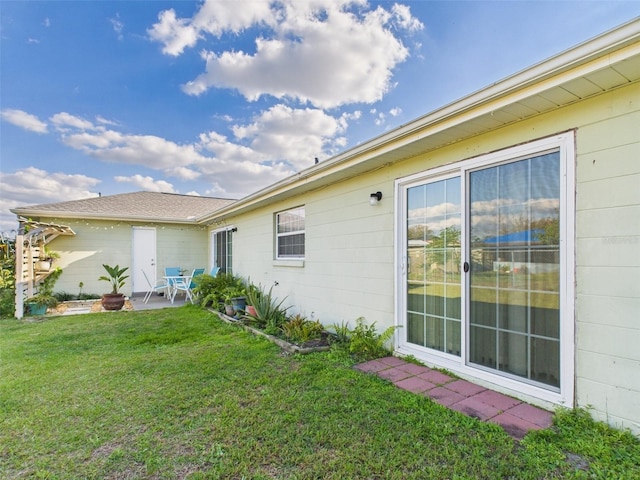 view of property exterior with a patio area and a yard