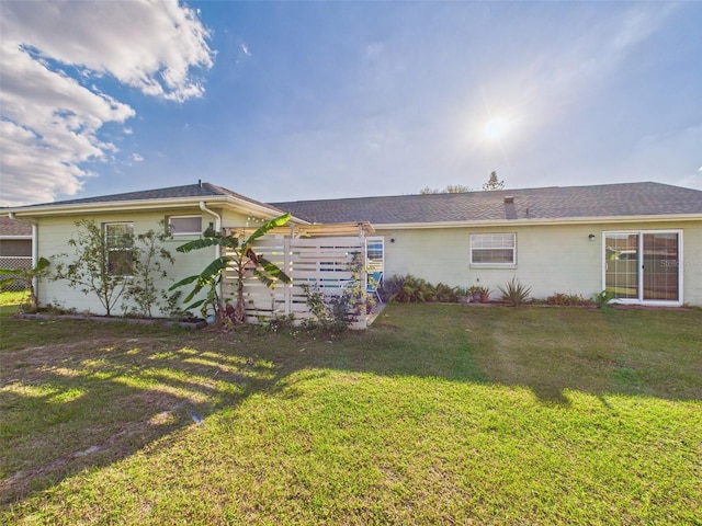 back of house featuring a yard and fence