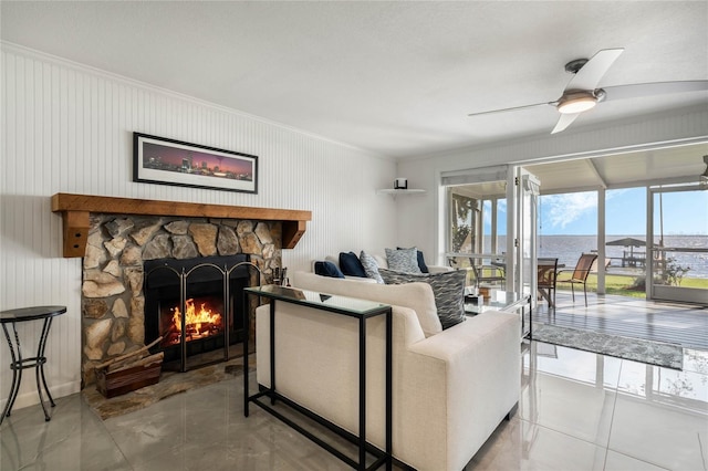 living area featuring ceiling fan, a fireplace, and crown molding