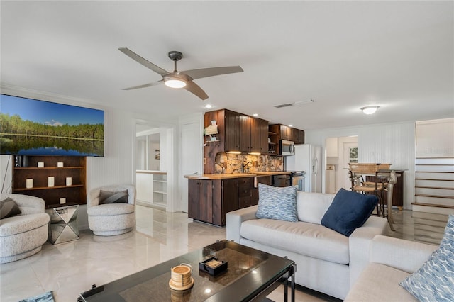 living area featuring marble finish floor, ceiling fan, visible vents, and stairway