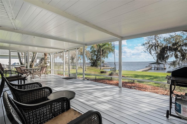 deck with outdoor dining area, a water view, and a grill