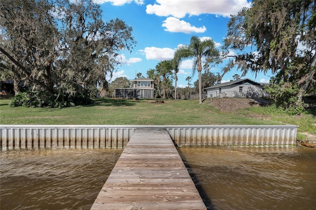 view of dock with a yard and a water view