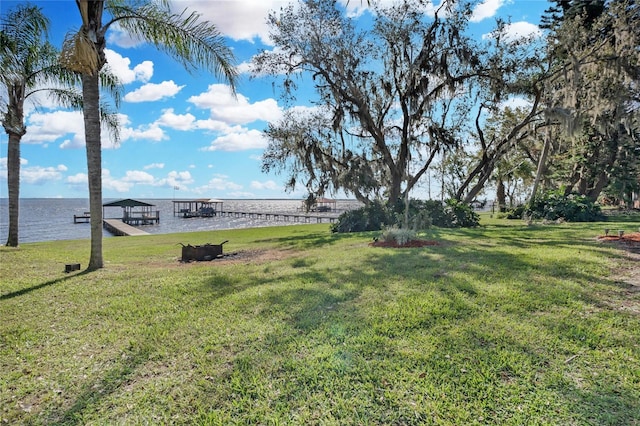 view of yard with a water view and a dock