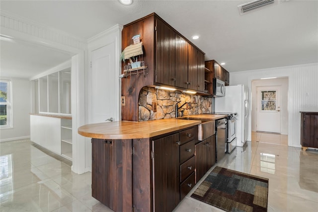 kitchen featuring open shelves, stainless steel microwave, visible vents, decorative backsplash, and dark brown cabinets