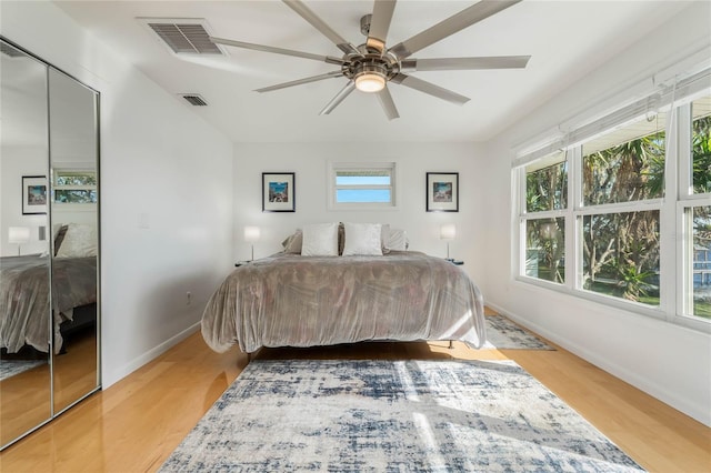 bedroom featuring baseboards, visible vents, ceiling fan, and light wood-type flooring