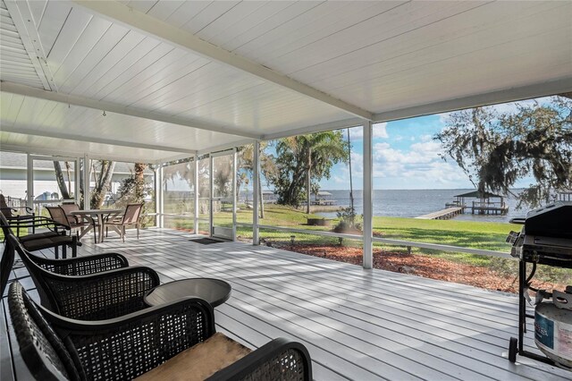 sunroom featuring a water view