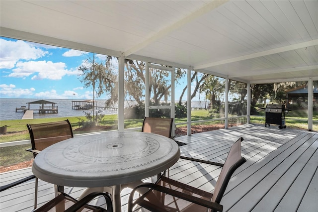 wooden deck with grilling area, a dock, and a water view