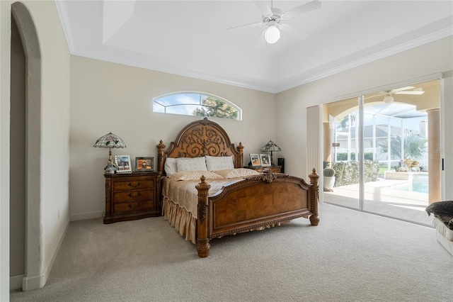 bedroom featuring access to exterior, a tray ceiling, light colored carpet, ornamental molding, and a ceiling fan