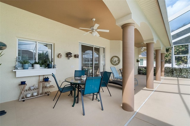 view of patio / terrace featuring glass enclosure and a ceiling fan