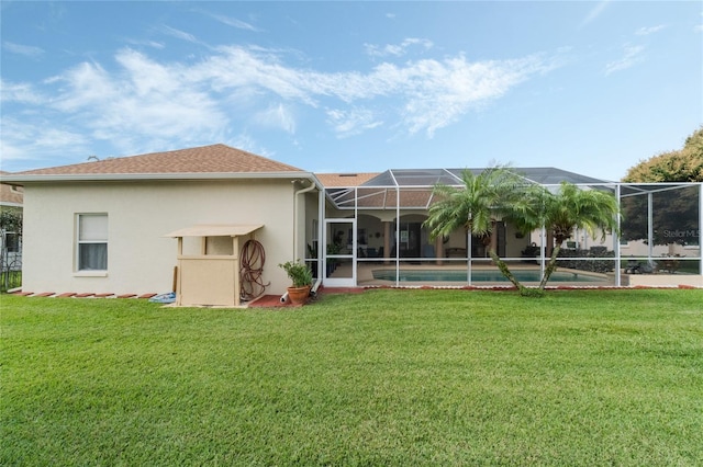 back of property with roof with shingles, glass enclosure, a yard, and stucco siding