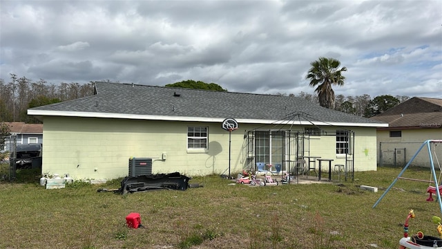 rear view of house with a playground, central air condition unit, a shingled roof, a lawn, and a gazebo