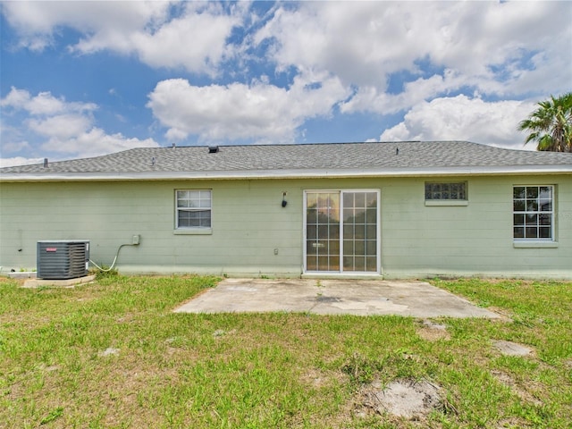 91 W Cedarwood Cir, Kissimmee, FL 34743 - rear view of property featuring central AC, a patio area, and a lawn