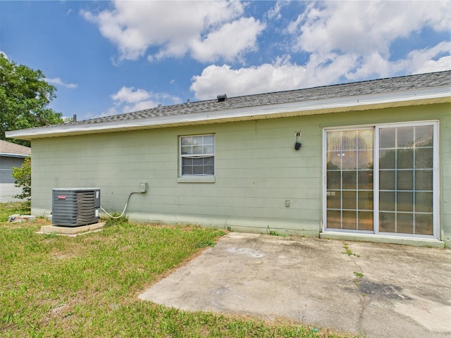 91 W Cedarwood Cir, Kissimmee, FL 34743 - rear view of property with central air condition unit, a patio, and a lawn
