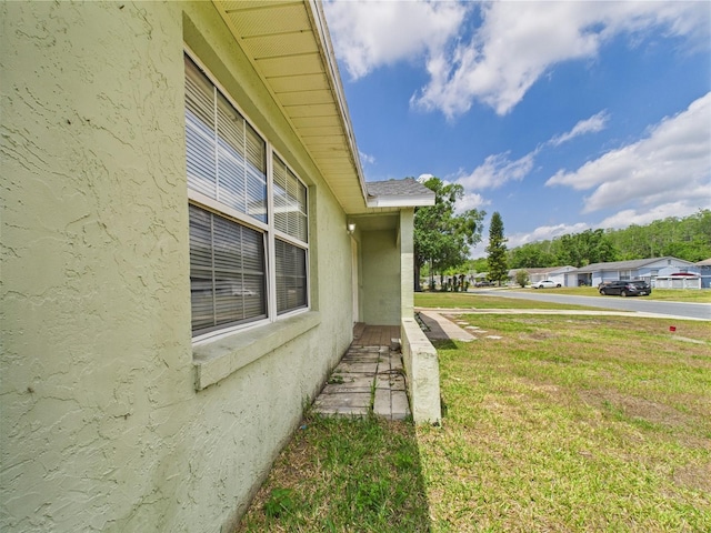 91 W Cedarwood Cir, Kissimmee, FL 34743 - view of side of home with stucco siding and a yard