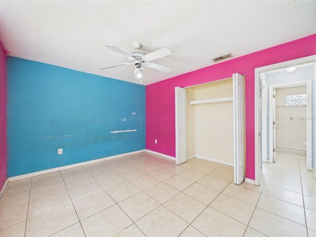 91 W Cedarwood Cir, Kissimmee, FL 34743 - unfurnished bedroom with tile patterned flooring, a ceiling fan, a textured ceiling, and baseboards