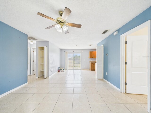 91 W Cedarwood Cir, Kissimmee, FL 34743 - empty room featuring a textured ceiling, ceiling fan, light tile patterned floors, and baseboards